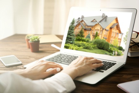 woman's hands on laptop keyboard with a home search on screen