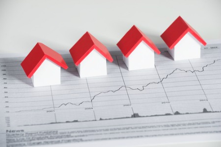 real estate market report concept of graph with small houses sitting on top